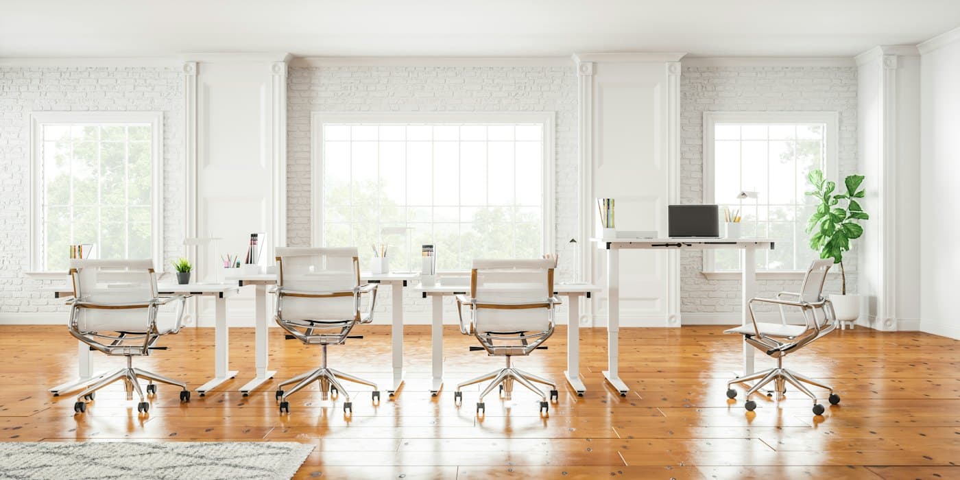 A bright open office with white desks and chairs