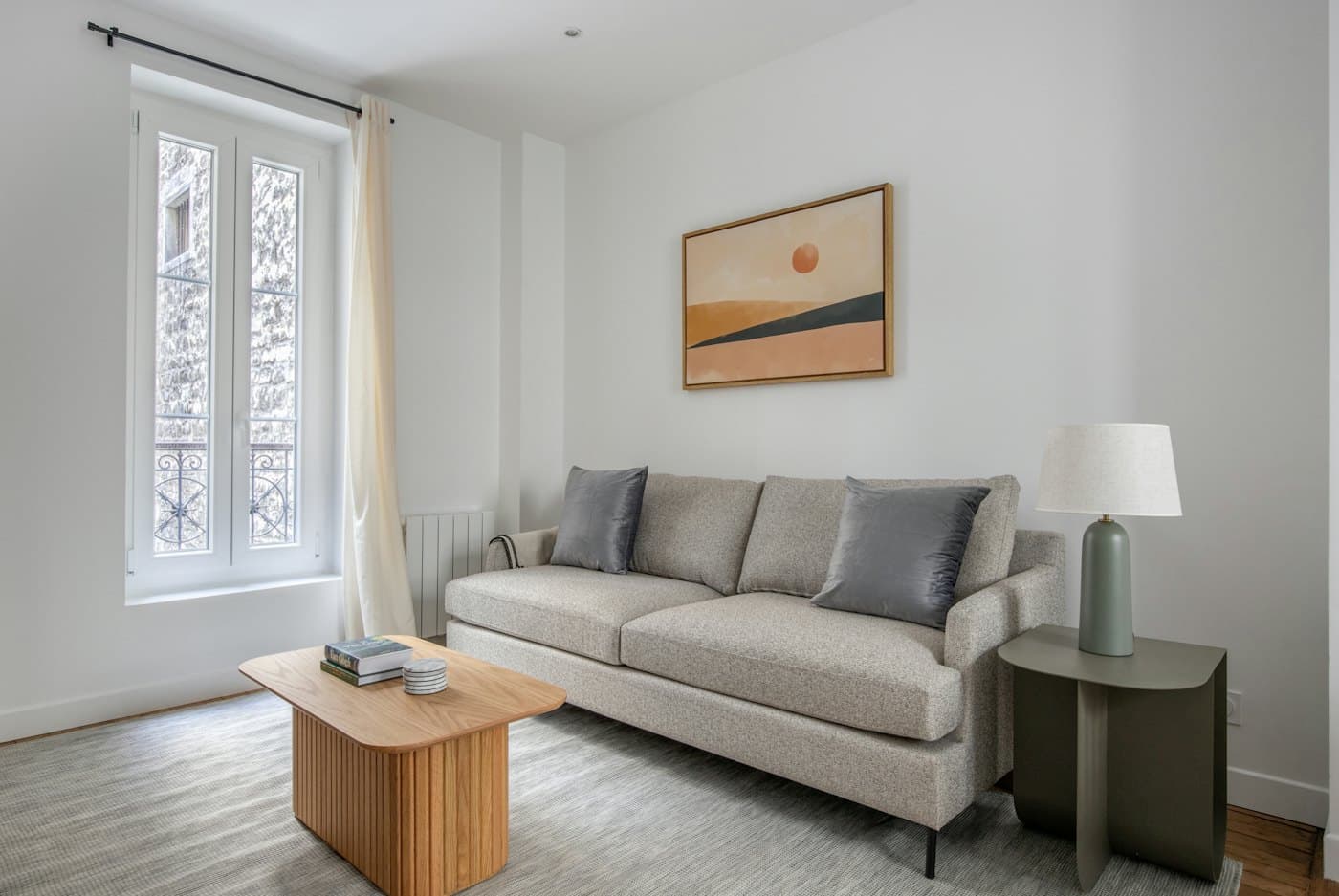 A tidy living room with a sofa, coffee table, and window
